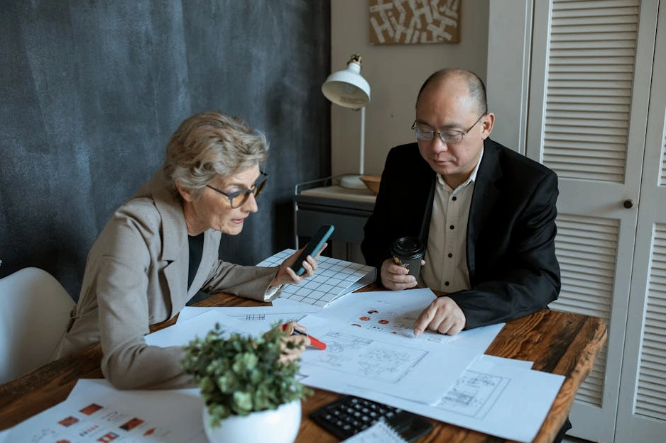 Diverse group of professionals in a meeting, discussing shareholder reports.
